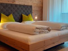 Zimmer Kronplatz mit Doppelbett und Balkon